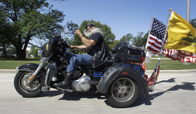 Dave Zien gives a thumbs up as he rolls down a road in New Berlin on his Harley-Davidson in August. Zien's former bike is now in the Harley-Davidson motorcycle hall of fame after he rode it for one million miles. Zien's current ride has a custom hand operated shifter since he lost his left leg in a motorcycle accident in Florida.